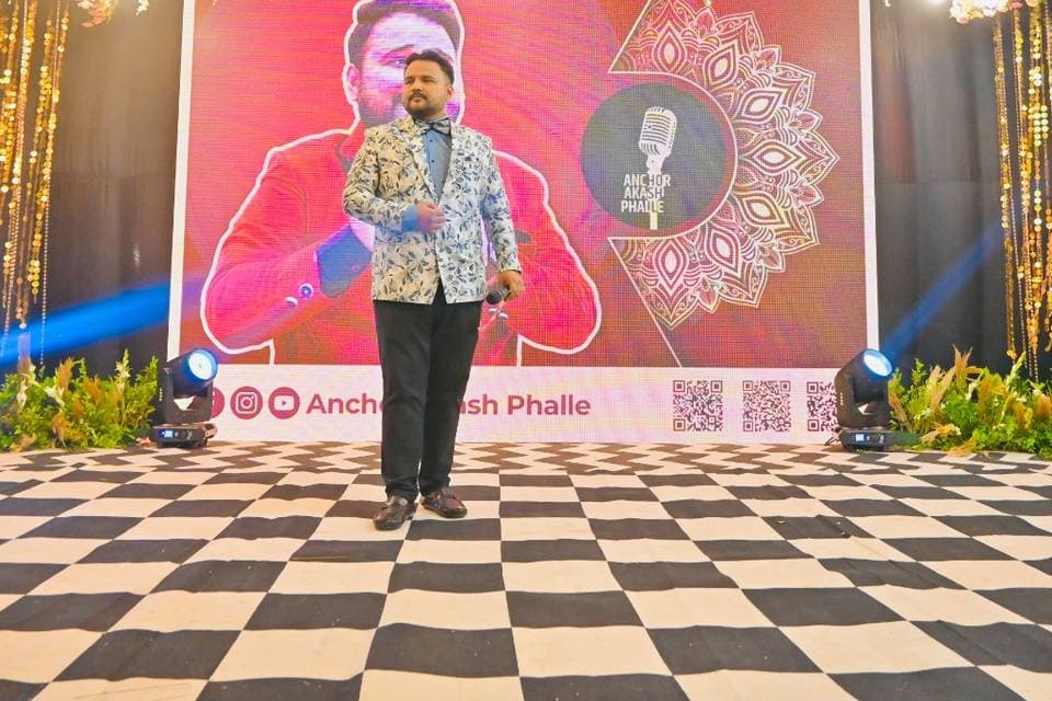 Anchor Akash Phalle on a decorated event stage